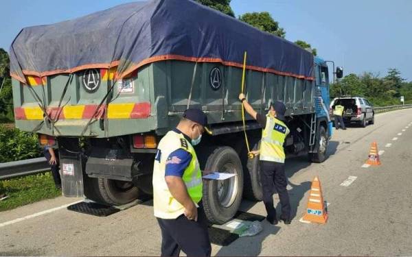 Anggota JPJ Pahang melakukan pemeriksaan ke atas lori yang ditahan dalam Ops Tutup yang diadakan sekitar Kuantan dan Pekan pada Isnin hingga Rabu lalu. - Foto JPJ Pahang