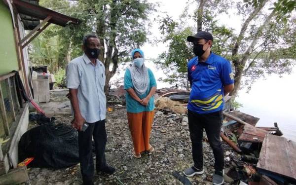 Abdul Yunus (kanan) melihat kesan hakisan yang berlaku berhampiran kediaman Suhaila.