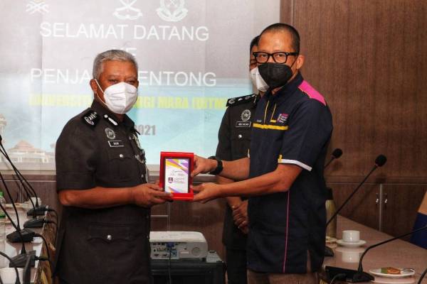 Ab.Basir (kiri) menerima cenderamata daripada Mohd Ilham