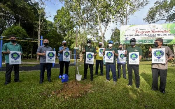 Takiyuddin (empat dari kiri) bergambar selepas menanam pokok Blue Quandong pada Program Berbasikal Penghijauan Malaysia Negeri Kelantan di Taman Perbandaran Tengku Anis hari ini. - Foto Bernama
