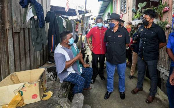 Menteri Pertanian dan Industri Makanan Datuk Seri Dr. Ronald Kiandee (tengah) bertanya sesuatu kepada salah seorang penduduk sewaktu turun padang bagi menjayakan program Walkabout ke Rumah Peserta Projek Khas Perumahan Nelayan (PKPN) dan menyampaikan bantuan Bakul Makanan Nelayan di Kampung Kolapis hari ini. - Foto Bernama
