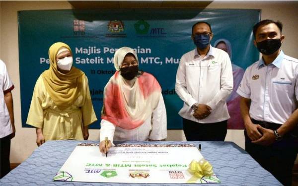 Zuraida (dua dari kiri) menandatangani replika plak sebagai tanda perasmian Pejabat Satelit Lembaga Perindustrian Kayu Malaysia (MTIB) dan Majlis Kayu-Kayan Malaysia (MTC) di Wisma Persatuan Perabot Muar (MFA) pada Isnin. - Foto Bernama