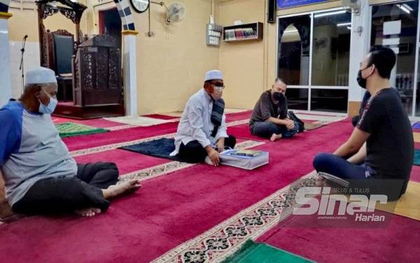 Eddy (kanan) menceritakan kisah hidupnya kepada Zulkifli (tengah) dan jawatankuasa Masjid Kariah Arraudah Taman Rasa Sayang, Seremban pada Isnin.
