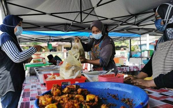 Juliana (tengah) melayani pelanggan yang berkunjung ke gerainya.