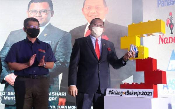 Mohd Khairuddin (kanan) membuat gimik pelancaran Jelajah Selangor Bekerja 2021 yang berlangsung di Dewan Jubli Perak, pada Selasa.
