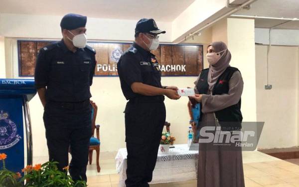 Noor Razlina (kanan) menyampaikan sumbangan kepada Shafien sambil diperhatikan Mohamad Ismail (kiri) di IPD Bachok pada Selasa. - Foto: SINAR HARIAN