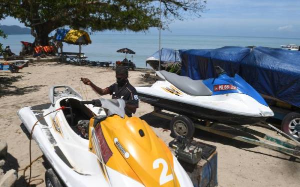 Jahir Mohd Ariff, 52, membaiki Jet Ski di pantai Batu Ferringhi di sini sebagai persediaan menyambut pelancong pada hujung minggu ini.