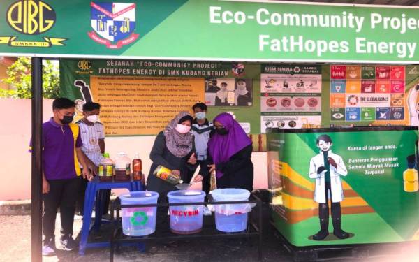 Pengetua Sekolah Menengah Kebangsaan (SMK) Kubang Kerian, Khairani Sabtu (tengah) menuang minyak masak ke penapis sebelum dimasukkan ke dalam tangki yang disediakan oleh pihak syarikah biodisel, FatHopes Energy Sdn Bhd.