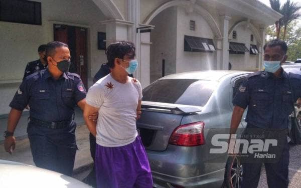 Ahmad Hafizuddin (tengah) dibawa keluar menuju ke kenderaan polis selepas dihadapkan ke Mahkamah Majistret Lipis pada Khamis.