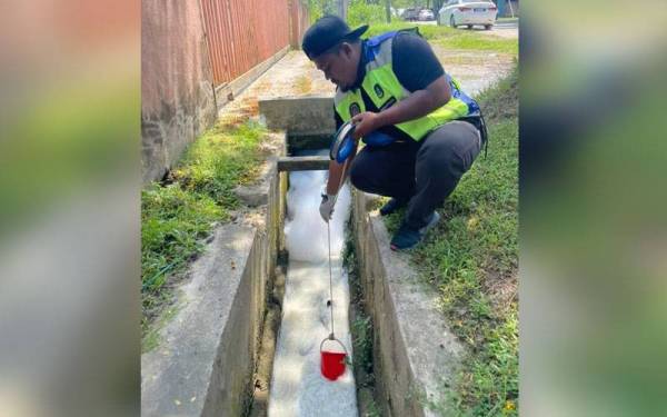 Kakitangan LUAS mengambil sampel air di longkang yang tercemar dengan warna putih seakan sabun.