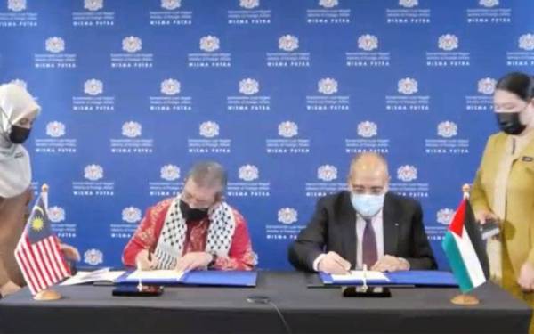 Saifuddin (dua dari kiri) dan Walid (dua dari kanan) ketika menandatangani Nota Pertukaran sumbangan di Wisma Putra, Putrajaya pada Khamis.