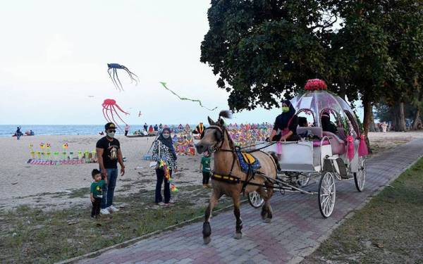 Pengunjung beriadah santai di Pantai Batu Burok selepas kerajaan membenarkan aktiviti rentas negeri di seluruh negara bermula 11 Oktober lepas.