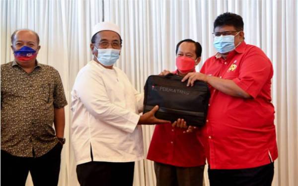 Ahmad Maslan (dua dari kanan) menyaksikan penyerahan komputer riba yang disampaikan Ab Rauf (kanan) kepada ADUN Kuala Linggi, Datuk Ismail Othman (dua dari kiri) yang merupakan wakil Pusat Daerah Mengundi BN Permatang pada Majlis Penyerahan Komputer Riba kepada UMNO Parlimen Masjid Tanah pada Jumaat. - Foto Bernama