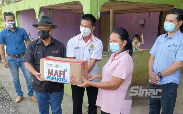 Ronald (dua dari kiri) ketika menyampaikan sumbangan MAFI Prihatin kepada penduduk sekitar Kampung Bauto, Telupid yang terjejas akibat pandemik Covid-19.