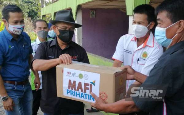 Ronald (tiga dari kiri) ketika menyampaikan sumbangan MAFI Prihatin kepada penduduk sekitar Kampung Bauto, Telupid yang terjejas akibat pandemik Covid-19.