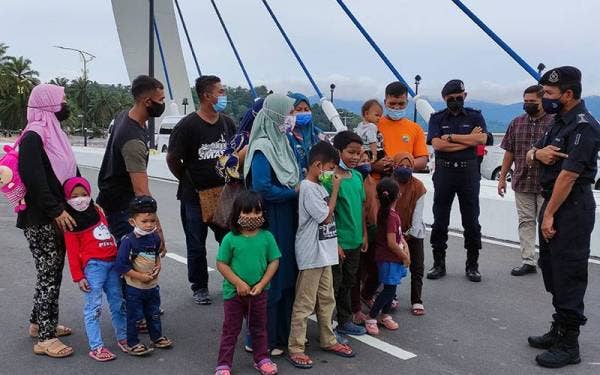 Rohaimi (kanan) bertanya sesuatu kepada pengunjung yang berkunjung ke Tasik Kenyir pada Sabtu.
