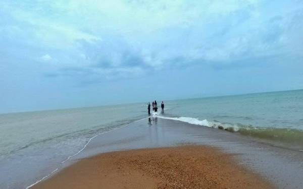 Orang ramai dilihat begitu teruja berjalan di tengah-tengah beting pasir yang dipercayai terbentuk akibat air surut.