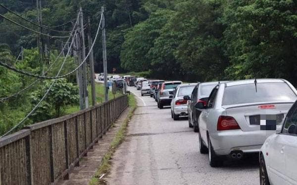 Kenderaan yang bergerak perlahan ketika melalui sekatan jalan raya di Sungai Lebey, Gerik pada Jumaat. - Foto Pembaca