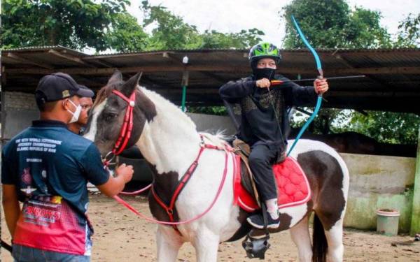 Jurulatih Persada Stud Farm Mohd Ridzuan Zakaria (kiri) melatih seorang peserta wanita menunggang kuda dan memanah sempena hari pembukaan Pusat Latihan Sukan Berkuda, Persada Stud Farm di Jeram Mengaji Agro Resort, Selising hari ini. Foto Bernama