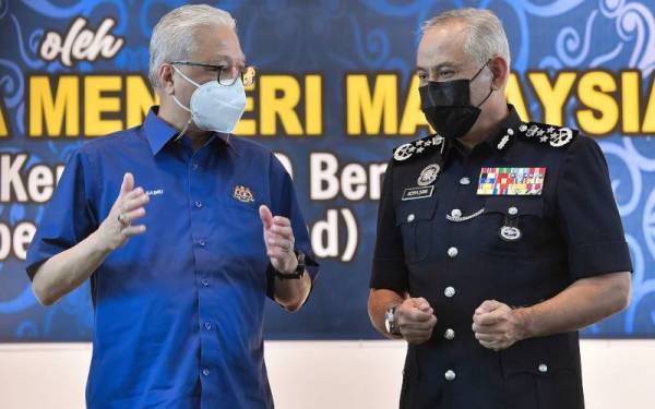 Ismail Sabri (kiri) memperkatakan sesuatu kepada Acryl Sani pada Upacara Pemakaian Pangkat Ketua Polis dan Timbalan Ketua Polis Daerah Bera hari ini. - Foto Bernama