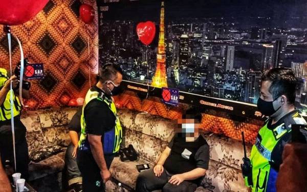 Kamarul Zaman (dua dari kiri) menyoal siasat pengunjung yang ditahan dalam serbuan di sebuah pusat hiburan di Mergong di sini pada malam Ahad.