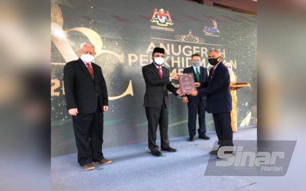 Dr Nik Muhammad Zawawi (dua dari kiri) menyampaikan Anugerah Perkhidmatan Cemerlang kepada Timbalan Pengurus Besar (Operasi) Lembaga Kemajuan Pertanian Kemubu (KADA), Mokhtar Zakaria pada Isnin.