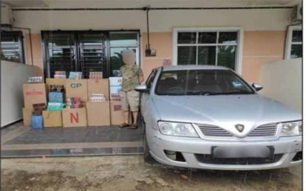 Suspek bersama barangan yang dirampas Batalion 6 PGA Bakri di Taman Bintang Emas, Bukit Pasir, Muar pada Ahad.