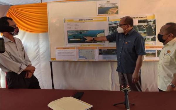 Izham (tengah) pada sesi taklimat pembinaan jambatan kedua menghubungkan Sungai Air Tawar Selangor ke Hutan Melintang Perak di Kampung Dato' Hormat, pada Isnin.