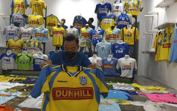 Mohd Almie (depan) bersama rakannya menyusun koleksi jersi pasukan bolą sepak Penang FA hampir 1,000 helai jersi pasukan itu untuk dijadikan sebagai koleksi dan memorial berharga. - Foto Bernama