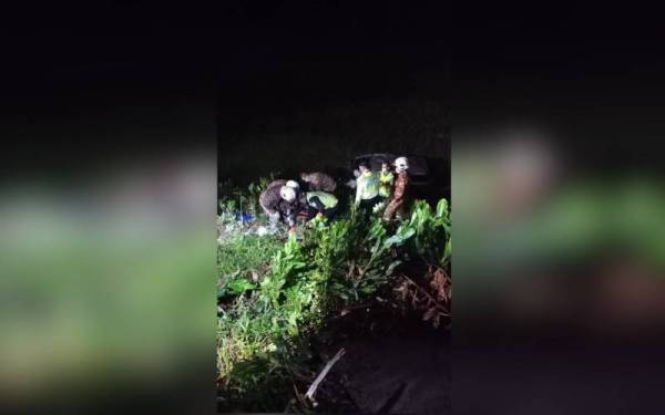 Anggota bomba ketika mengeluarkan mangsa daripada kereta yang terbabas dalam kejadian itu.