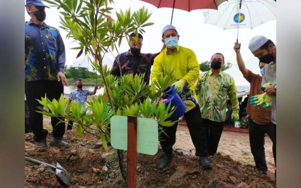Tuan Mohd Saripudin (tiga dari kanan) menanam pokok sebagai simbolik perasmian Hari Alam Sekitar Negara (HASN) Peringkat Negeri Kelantan di Taman Rekreasi Bukit Gedombak, Pasir Puteh pada Khamis.