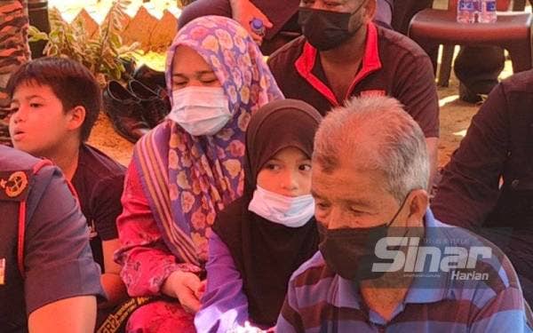 Noraidah (tengah) bersama ahli keluarga ketika pengebumian suaminya anggota bomba Allahyarham Mohd Diya.