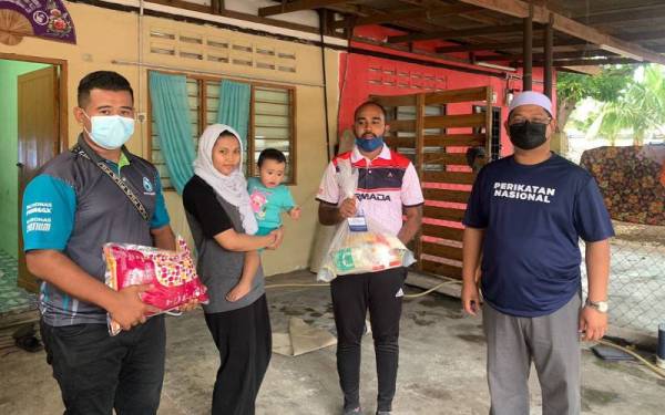 Afiq (dua dari kanan) menyampaikan sumbangan kepada mangsa banjir.
