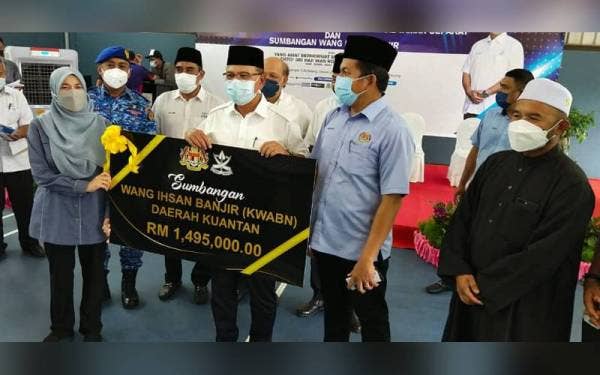 Wan Rosdy menyerahkan replika cek bantuan wang ihsan banjir kepada Pegawai Daerah Kuantan,Tengku Datuk Norasmaliza Ku Lah pada Penyerahan Surat Hak Milik Kekal Taman Sepakat dan Penyerahan Bantuan Wang Ihsan Banjir Daerah Kuantan di Dewan Taman Sepakat pada Jumaat.