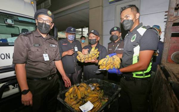 Ronald (tengah) ketika melihat hasil pertanian yang akan dieksport ke Singapura pada lawatan di Kompleks Kastam dan Imigresen Bangunan Sultan Iskandar di sini pada Jumaat.