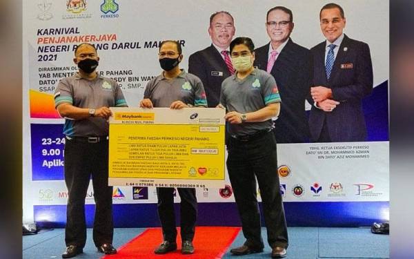 John Riva (kanan) menyerahkan replika cek simbolik bayaran kepada penerima Faedah Perkeso Negeri Pahang kepada Wan Rosdy pada Majlis Perasmian Karnival Penjana Kerjaya Negeri Pahang di Wisma Perkeso Negeri Pahang di sini pada Sabtu.