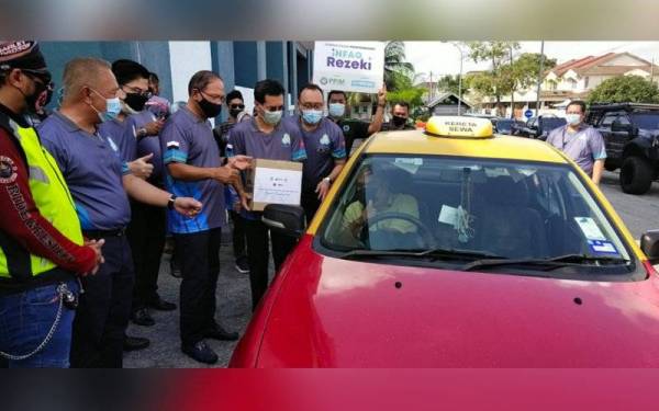 Wan Rosdy menyampaikan Bakul Prihatin kepada wakil pemandu teksi dan van sekolah yang terpilih di bawah Skim Keselamatan Sosial Pekerjaan Sendiri.