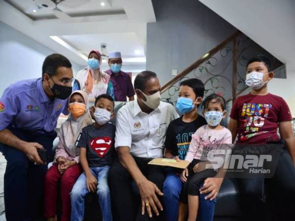 Saravanan (tengah) bersama Ketua Eksekutif Perkeso, Datuk Seri Dr Mohammed Azman Aziz Mohammed (kiri) ketika mengadakan pertemuan dengan lima beradik yang menjadi yatim piatu selepas kehilangan ibu bapa mereka akibat Covid-19 di Seri Kembangan pada Sabtu. FOTO SINAR HARIAN/ASRIL ASWANDI SHUKOR