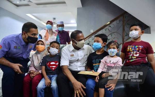 Saravanan (duduk, tengah) bersama Ketua Eksekutif Perkeso, Datuk Seri Dr Mohammed Azman Aziz Mohammed (duduk, kiri) ketika mengadakan pertemuan dengan lima beradik yang menjadi yatim piatu selepas kehilangan ibu bapa mereka akibat Covid-19 di Seri Kembangan pada Sabtu. FOTO SINAR HARIAN/ASRIL ASWANDI SHUKOR