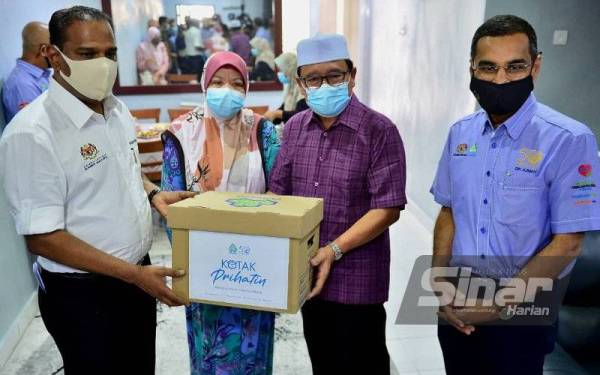 Saravanan (kiri) menyerahkan sumbangan kepada penjaga lima beradik yang kehilangan ibu bapa akibat Covid-19, Abdul Razak (dua dari kanan) dan Intan Sulaiman, 63, (dua dari kiri). FOTO SINAR HARIAN/ASRIL ASWANDI SHUKOR
