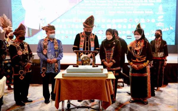 Tun Juhar diiringi isteri Toh Puan Norlida memotong kek selepas merasmikan Hari Etnik Sabah sempena Hari Jadi Tuan Yang Terutama Yang Ke-68 hari ini.Turut sama Hajiji Noor (dua, kiri) dan Timbalan Ketua Menteri merangkap Menteri Pembangunan Perindustrian, Datuk Joachim Gunsalam (kiri). - Foto Bernama