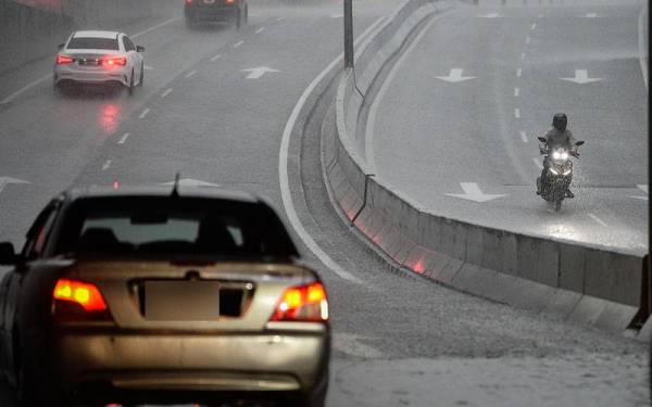 Penunggang motosikal berteduh di bawah jambatan daripada cuaca hujan yang turun sebentar petang tadi ketika tinjauan hujan lebat hari ini.