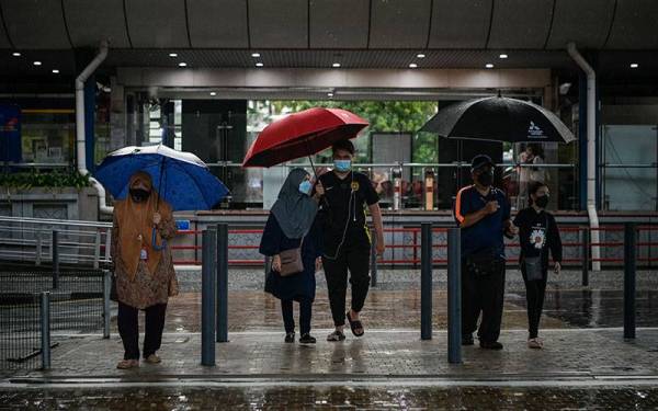 Beberapa orang awam menggunakan payung meredah cuaca hujan ketika tinjauan di sekitar ibu kota hari ini.