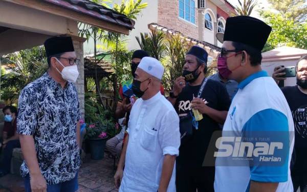 Ahmad Faizal (kiri) menziarahi jenazah Allahyarham Mamat Khalid.