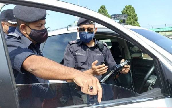 Ayob Khan (kiri) mendengar penerangan tentang ICOOP daripada anggotanya ketika Op Khas Bersepadu Kenderaan Perdagangan di Plaza Tol Skudai di sini pada Ahad.