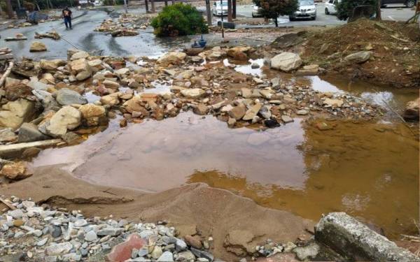 Laluan kenderaan yang rosak dipenuhi batu selain menjadi laluan pergerakan sungai 'baharu' akibat runtuhan tanah dan banjir kilat di lokasi tragedi kepala air Titi Hayun.