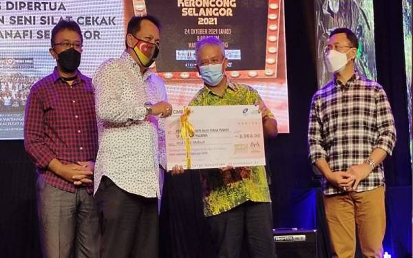 Noor Zari (dua dari kanan) menyerahkan replika cek bernilai RM2,000 kepada wakil Persekutuan Seni Silat Cekak Pusaka Hanafi Selangor.