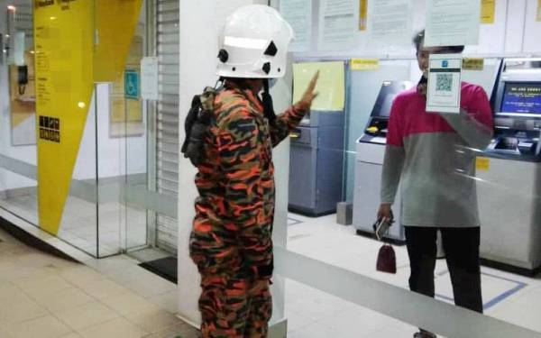 Seorang penghantar makanan yang terperangkap di dalam sebuah bank menempatkan ATM di Tanjong Karang pada Isnin.