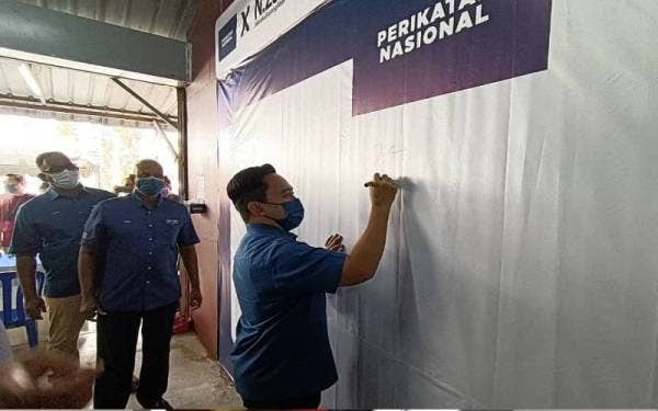 Wan Saiful (kanan) ketika menandatangani Bilik Gerakan Perikatan Nasional (PN) di Telok Mas, Melaka pada Isnin.