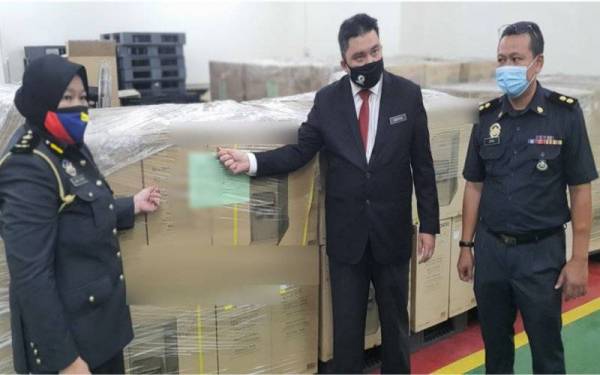 Ariffin Samsudin (tengah) menunjukkan produk yang dirampas.